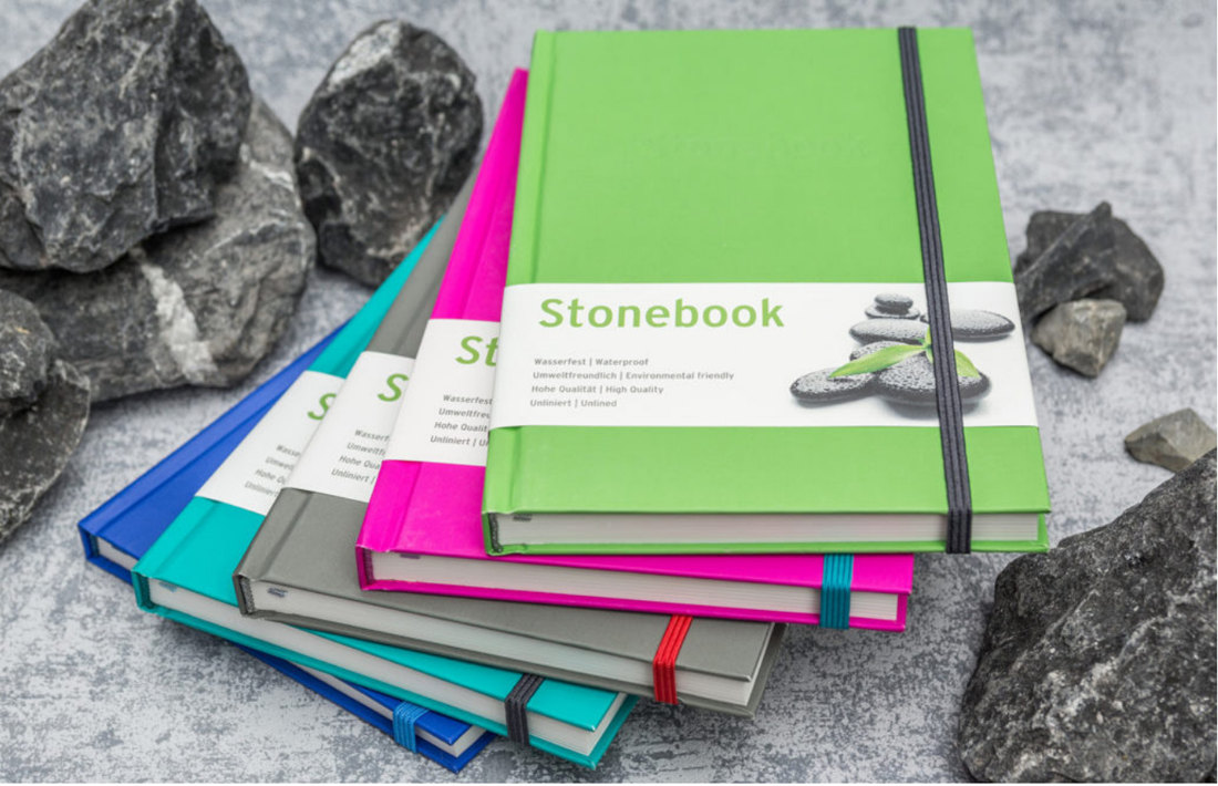 Блокноты Stonebook из каменной бумаги разных цветов на фоне камней